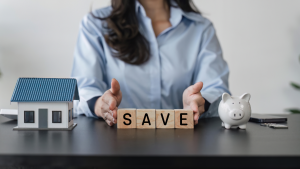 A woman at a table with her hands around blocks that spell out "save".